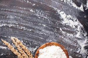 Wheat flour in bowl and ears
